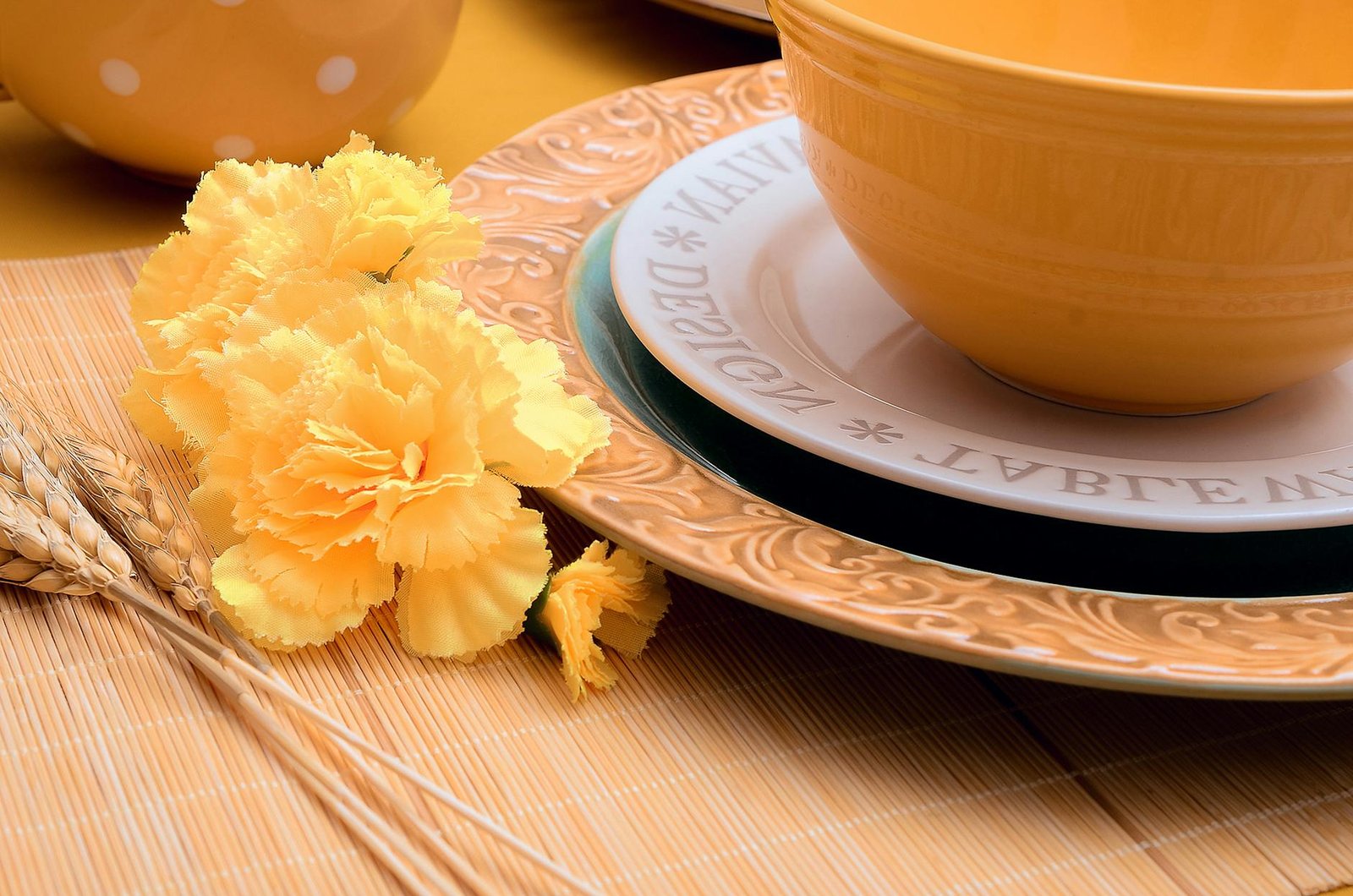 Elegant yellow floral arrangement with ceramic dishware, perfect for summer dining decor.