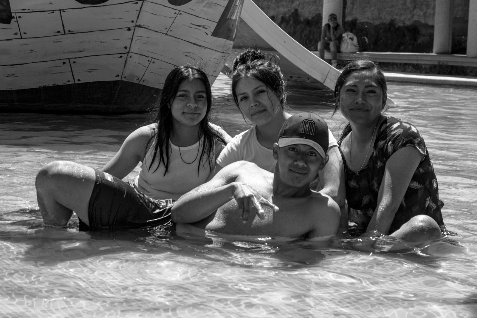 Black and white photo of friends enjoying a sunny day by a pool in Puebla, México.