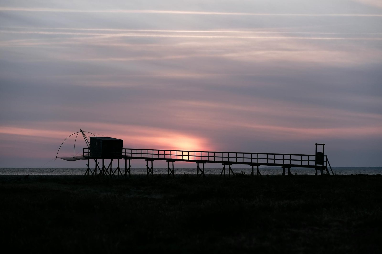 Beautiful sunset over a fishing pier in Les Moutiers-en-Retz, France.