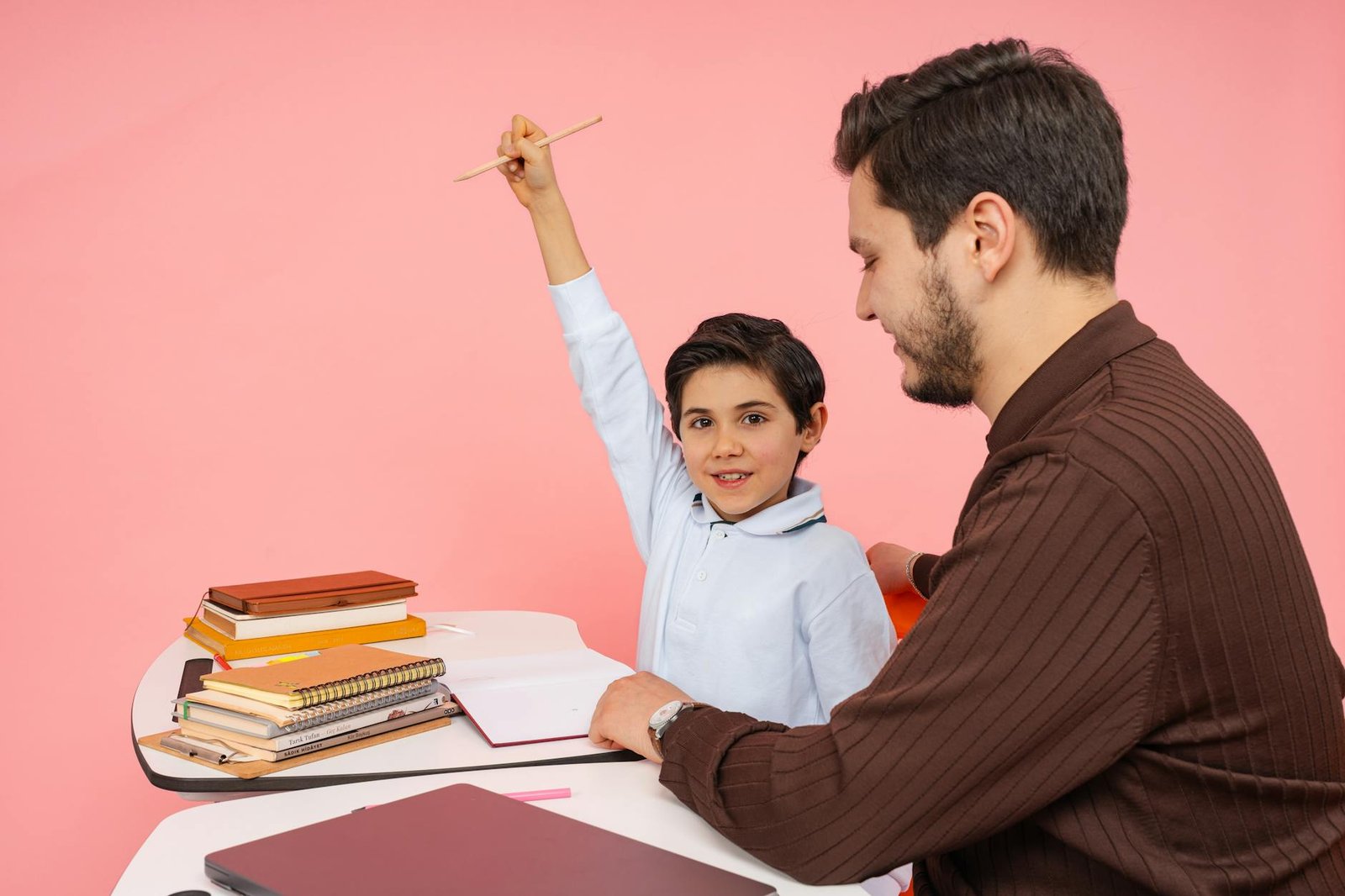 Teacher aids enthusiastic student in classroom setting, enhancing learning experience.