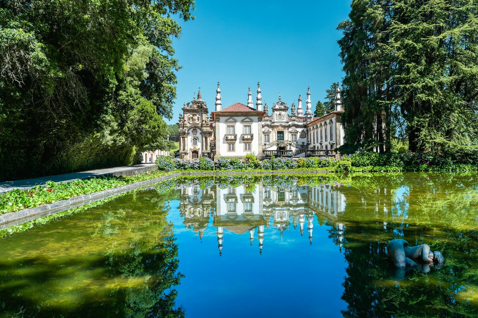 Stunning view of Casa de Mateus reflected in tranquil waters. Iconic Baroque architecture in Portugal.