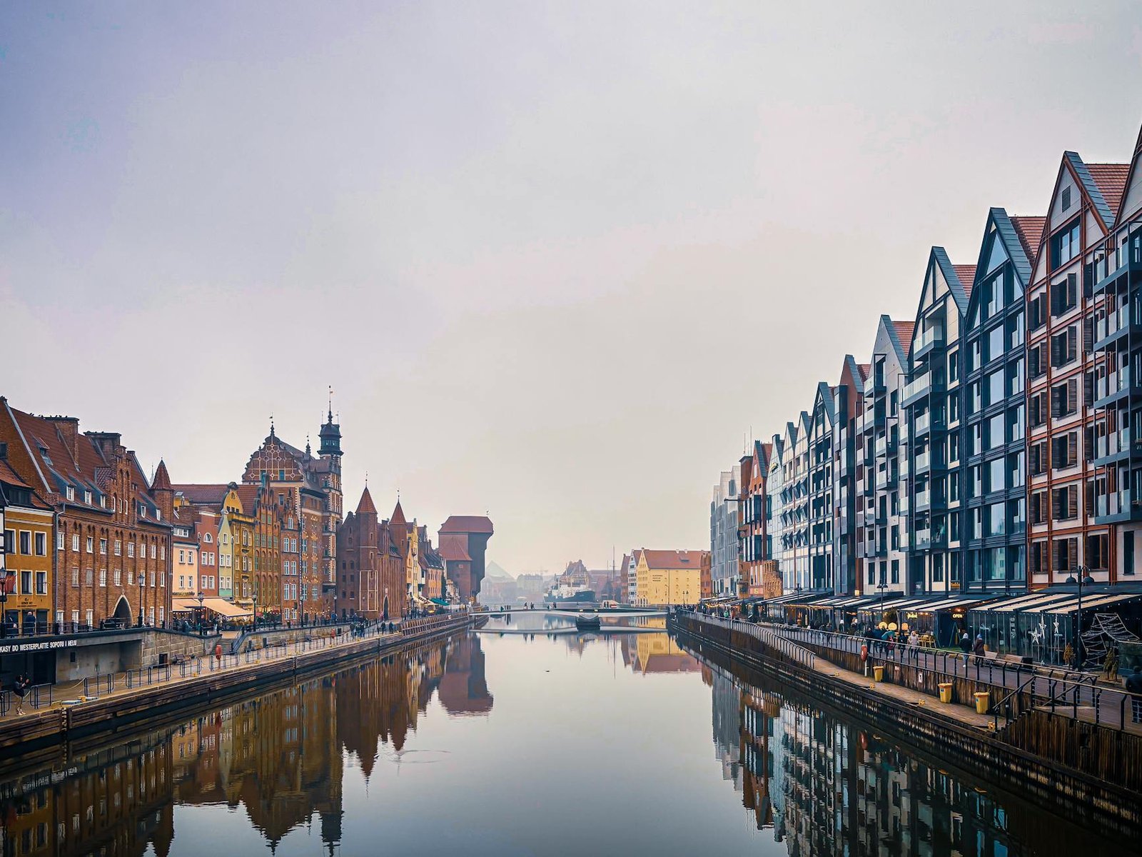 Scenic view of Gdańsk's historic architecture along the Motława River with reflections.