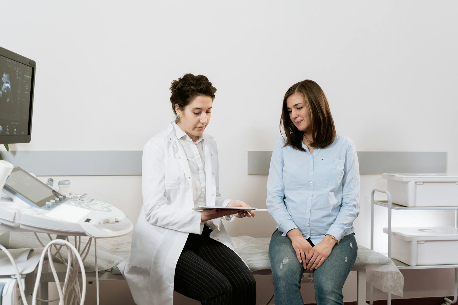 A pregnant woman consulting with a gynecologist in a medical facility.