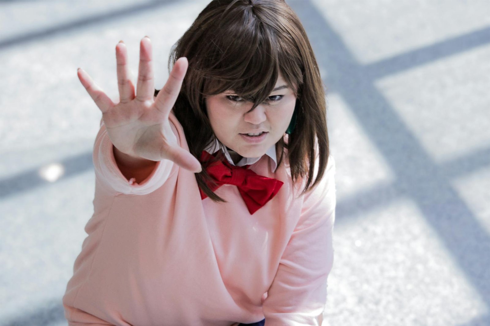 Young adult in anime-inspired cosplay, energetically posing indoors.
