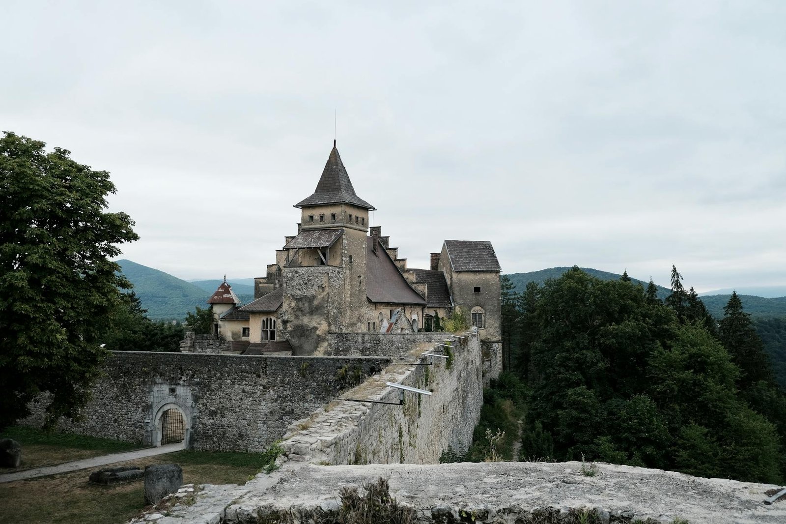 Explore the medieval Ostrozac Castle, nestled among lush hills, with its fortified walls and towers.
