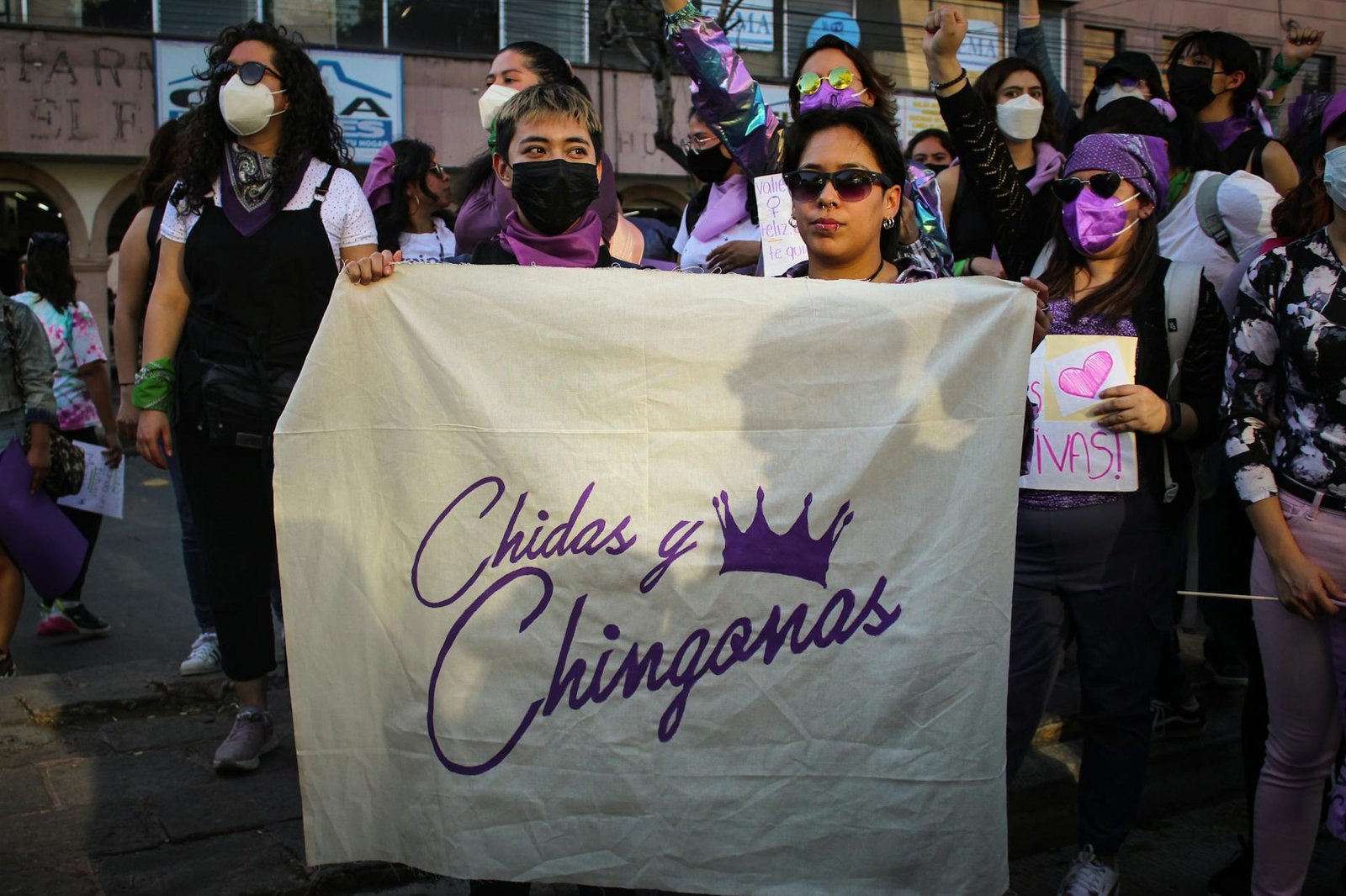 Group of women at a demonstration holding a banner promoting empowerment.