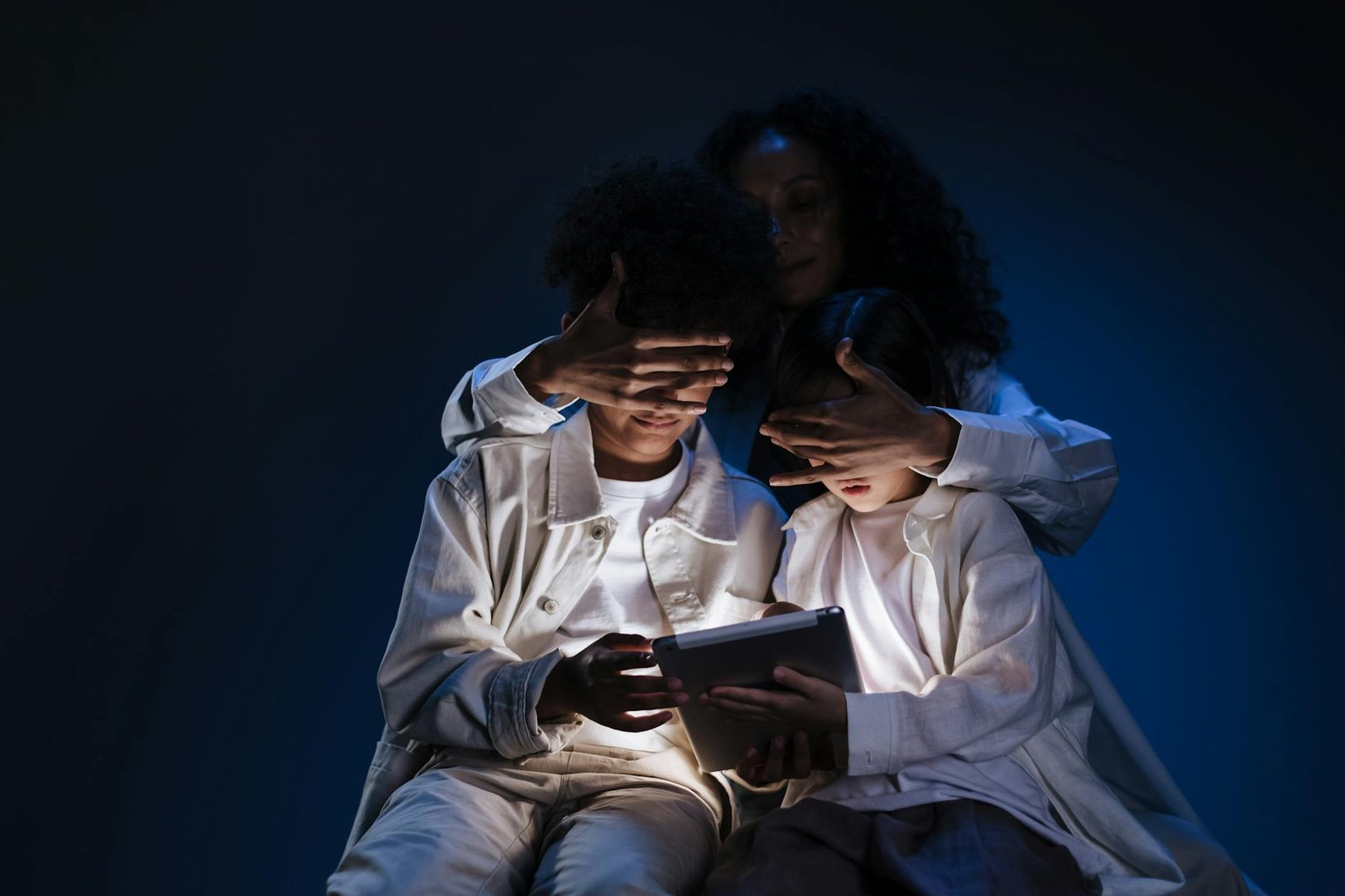 A mother oversees her children using a tablet, emphasizing safety and supervision in digital media use.
