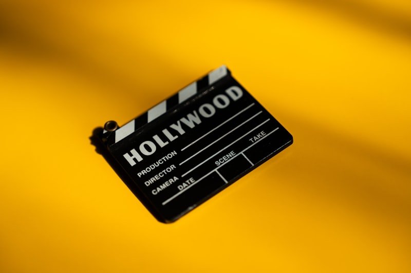 A hollywood movie clapperboard on a yellow background.