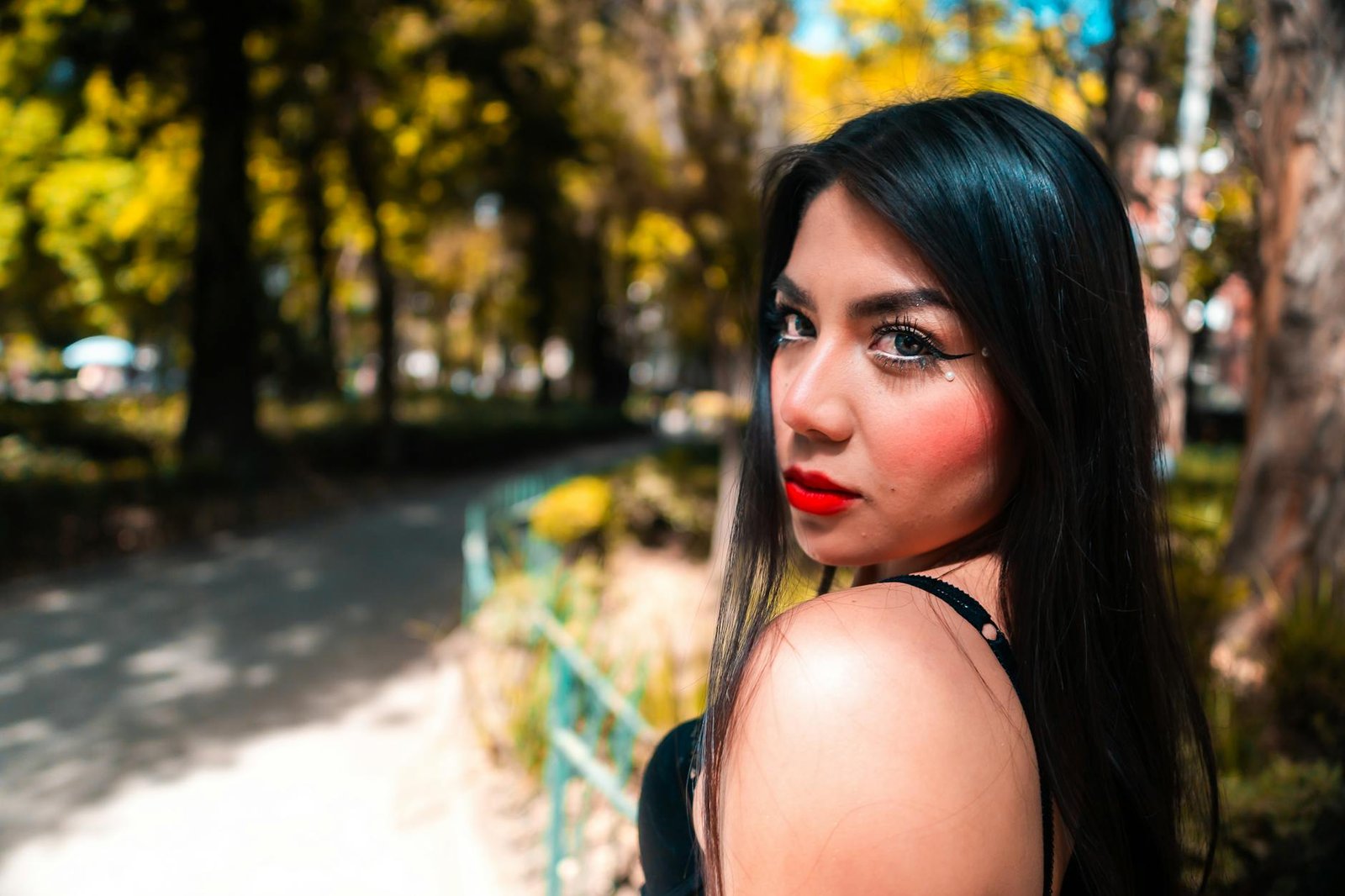 Stylish portrait of a woman in a vibrant park in Mexico City with autumn colors.